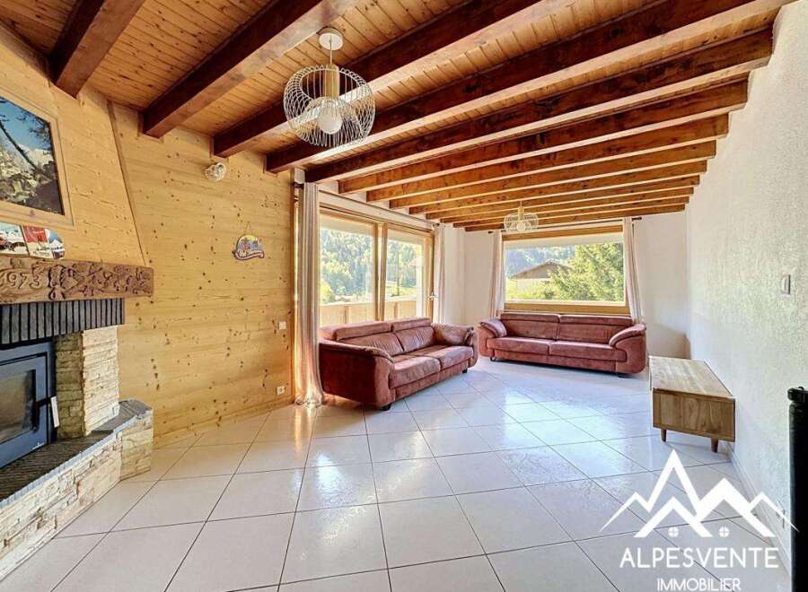 Discover the charm of this stunning property, featuring a cozy living room with a fireplace and exposed wooden beams.
