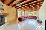 Discover the charm of this stunning property, featuring a cozy living room with a fireplace and exposed wooden beams.