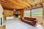 Discover the charm of this stunning property, featuring a cozy living room with a fireplace and a beautiful wooden ceiling.