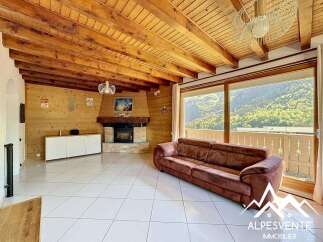 Discover the charm of this stunning property, featuring a cozy living room with a fireplace and a beautiful wooden ceiling.