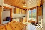 Discover this charming property featuring a cozy kitchen with wooden cabinets and a dining area.