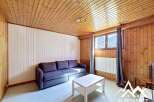 Discover this charming property featuring a cozy living space with wooden paneling and a comfortable sofa.