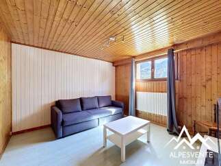 Discover this charming property featuring a cozy living space with wooden paneling and a comfortable sofa.