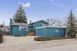 This charming home boasts a striking teal exterior, offering curb appeal.