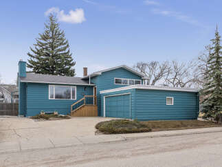 This charming home boasts a striking teal exterior, offering curb appeal.