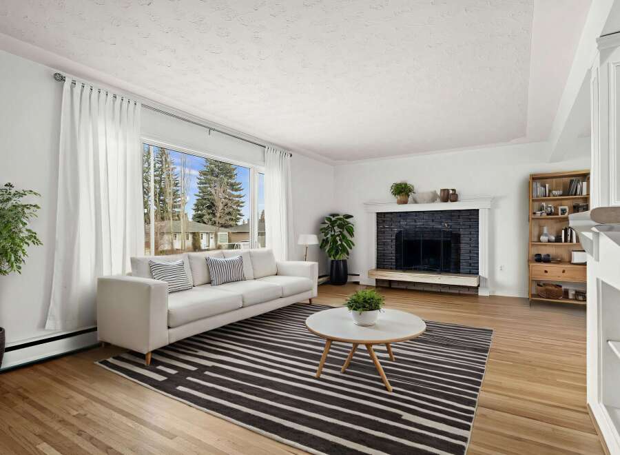 Step into this inviting living space, featuring a cozy fireplace and a stylish rug.