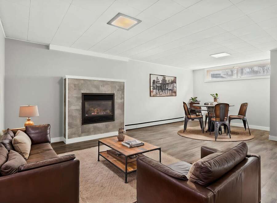Step into luxury with this stunning living space, featuring a cozy fireplace and elegant leather seating.