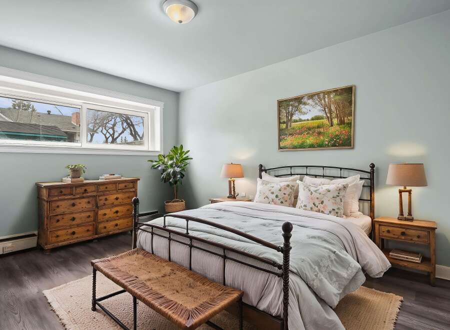 Step into this serene bedroom, featuring a charming wrought iron bed and a calming color palette.