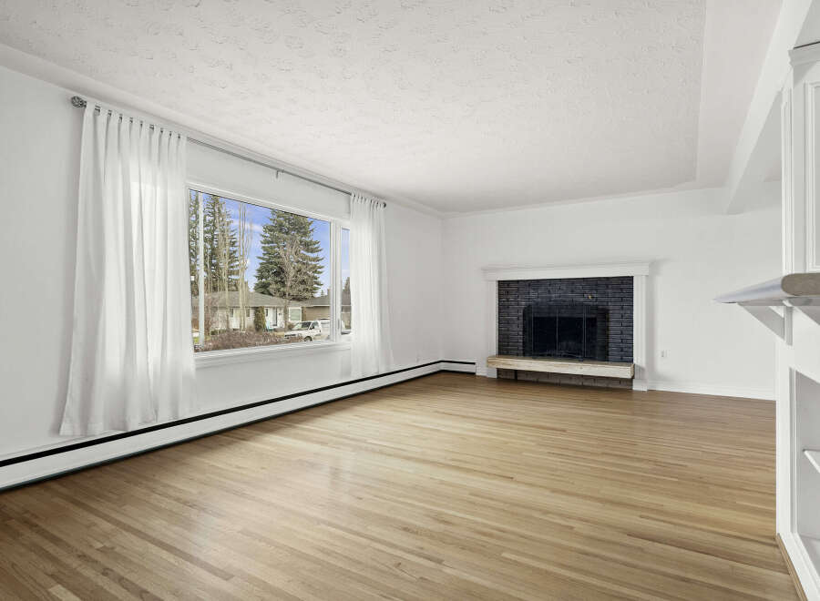 This spacious living room boasts beautiful hardwood floors and a cozy fireplace, perfect for relaxing evenings.