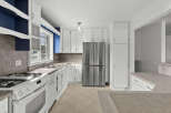 This bright and airy kitchen features white cabinetry, offering ample storage space.