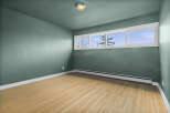 This inviting room features a fresh, modern aesthetic with its light-toned hardwood floors and calming teal walls.