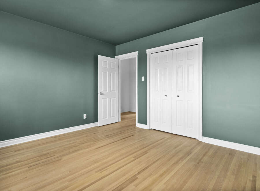 This inviting room features a fresh, modern aesthetic with its soothing teal walls and pristine white trim.