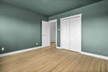 This inviting room features a fresh, modern aesthetic with its soothing teal walls and pristine white trim.