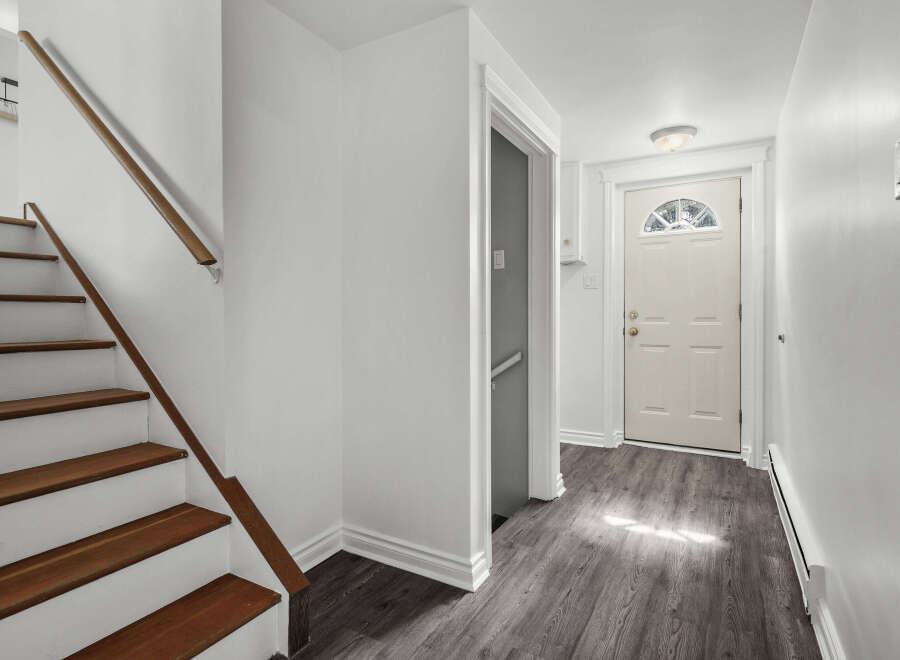 Step into this inviting entryway with a beautiful staircase and a welcoming front door.