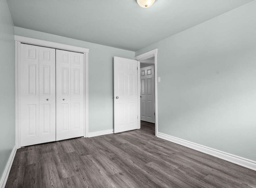 This inviting room showcases a modern aesthetic with its sleek, gray wood-look flooring and soft, light blue walls.