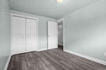 This inviting room showcases a modern aesthetic with its sleek, gray wood-look flooring and soft, light blue walls.