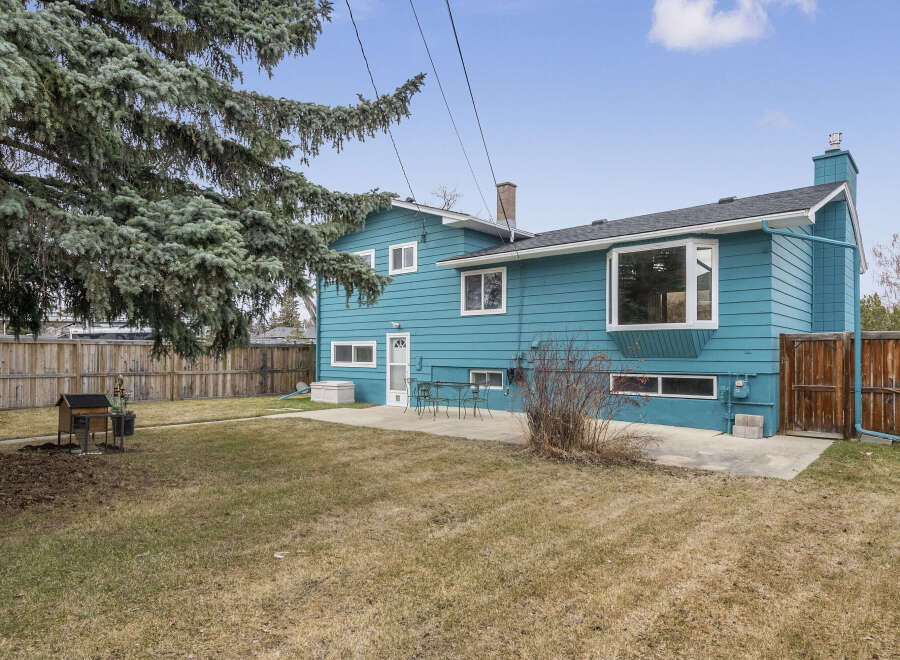 Discover this charming property featuring a vibrant blue exterior and a well-maintained backyard.