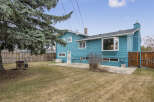 Discover this charming property featuring a vibrant blue exterior and a well-maintained backyard.