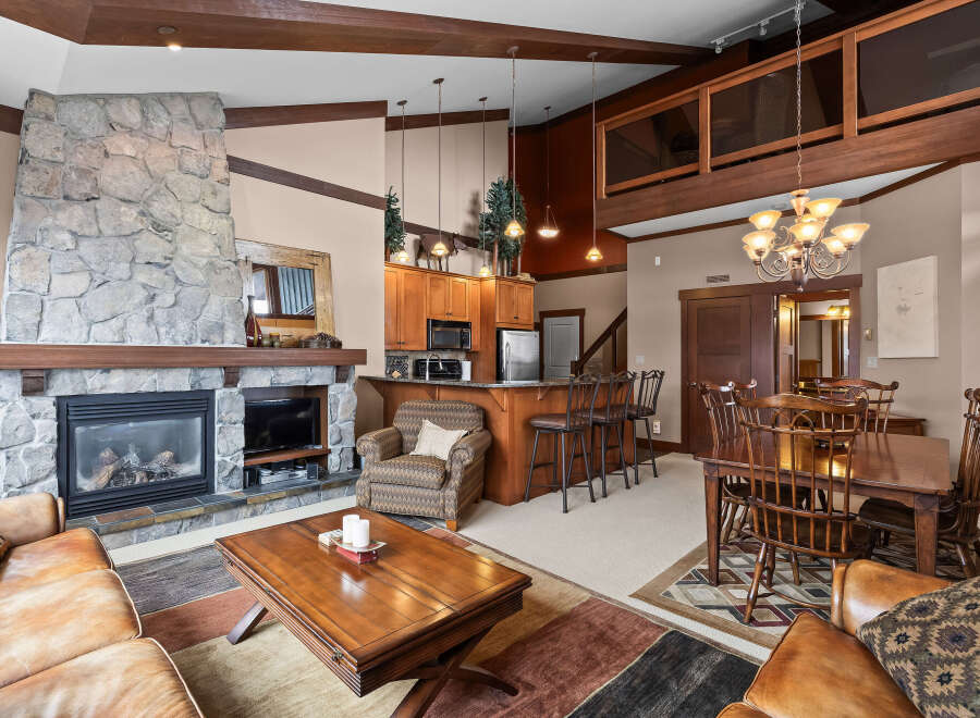 This stunning property boasts a cozy living room with a stone fireplace, perfect for relaxing evenings.