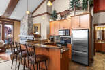 This stunning kitchen boasts a rustic charm with its stone fireplace and wooden cabinetry.