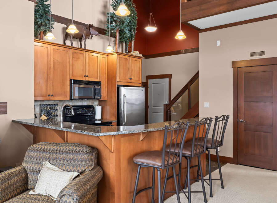 This stunning kitchen boasts beautiful wooden cabinetry and a sleek granite countertop, perfect for preparing meals and entertaining guests.
