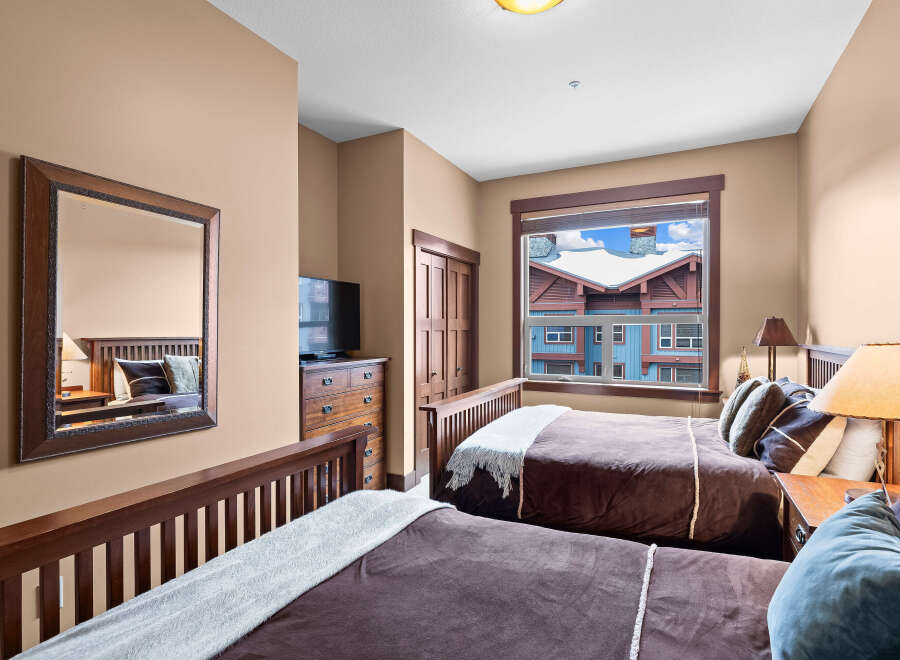 This cozy bedroom features two comfortable beds with plush bedding, perfect for a relaxing stay.