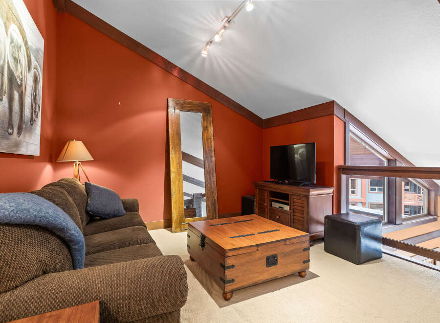 This stunning living space boasts a cozy ambiance with its rich, warm color palette and inviting furnishings.