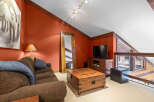 This stunning living space boasts a cozy ambiance with its rich, warm color palette and inviting furnishings.