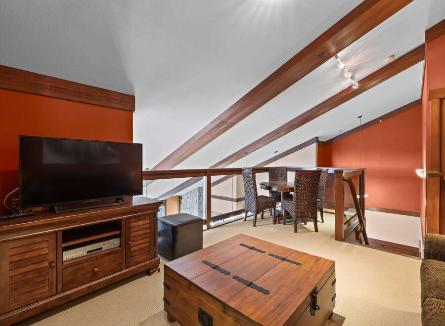 This stunning property boasts a spacious living area with a modern entertainment center and a cozy seating area.