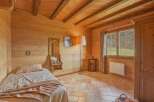 Step into a cozy bedroom retreat with warm wooden walls and a charming ambiance.