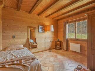 Step into a cozy bedroom retreat with warm wooden walls and a charming ambiance.