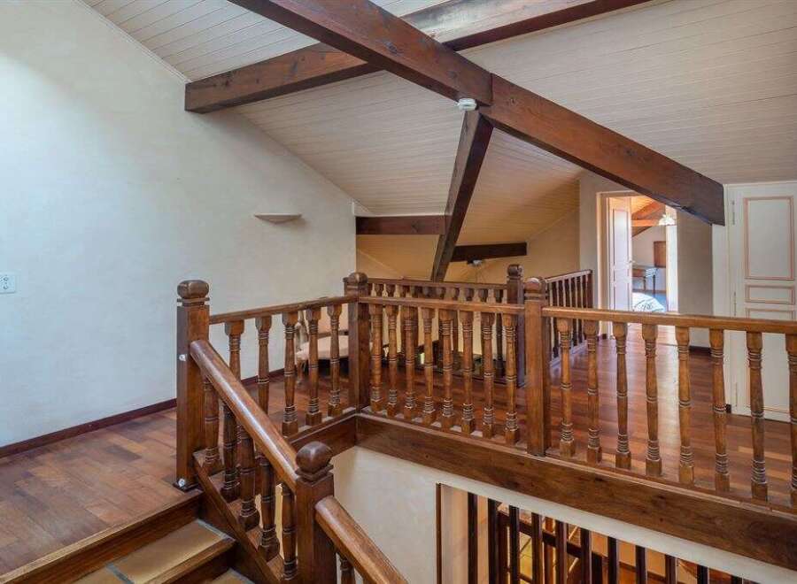 This stunning property boasts a beautifully crafted wooden staircase and railing, adding a touch of elegance to the interior.