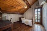 This charming bedroom features a warm wooden ceiling and flooring, creating a cozy and inviting atmosphere.