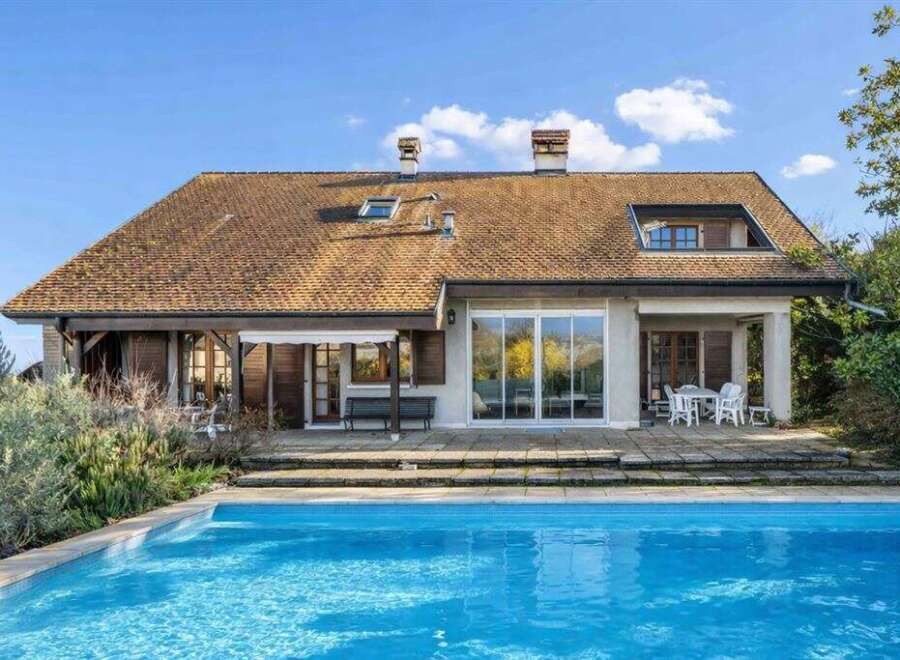 This stunning property boasts a beautiful home with a charming roof and a refreshing pool.