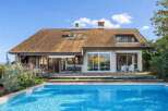 This stunning property boasts a beautiful home with a charming roof and a refreshing pool.