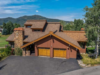 This stunning property boasts a beautiful exterior with a combination of wood and stone elements, creating a warm and inviting atmosphere.