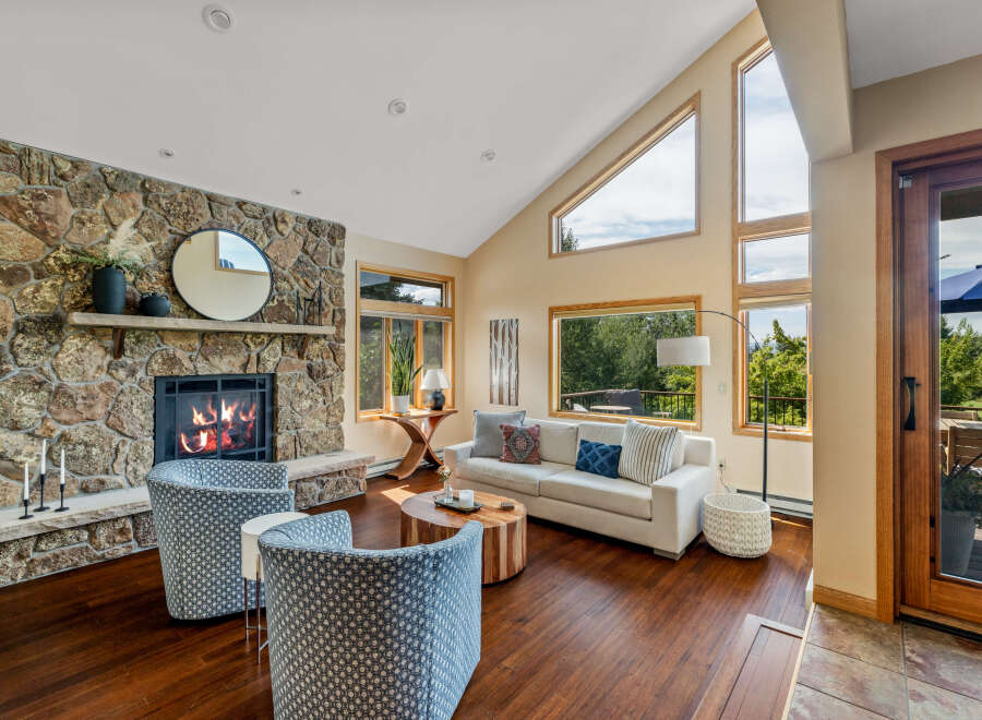 This stunning living room boasts a cozy fireplace with a stone surround, perfect for those chilly evenings.
