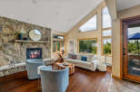 This stunning living room boasts a cozy fireplace with a stone surround, perfect for those chilly evenings.