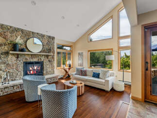 This stunning living room boasts a cozy fireplace with a stone surround, perfect for those chilly evenings.