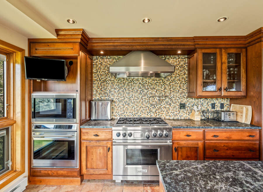 This stunning kitchen boasts custom cabinetry and high-end stainless steel appliances, perfect for the discerning chef.