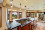 This stunning kitchen boasts a beautiful granite countertop and rich wooden cabinetry, creating a warm and inviting atmosphere.