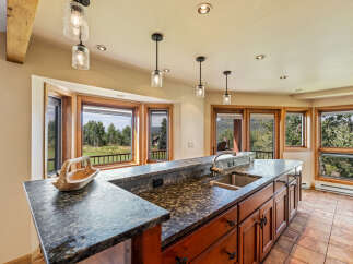 This stunning kitchen boasts a beautiful granite countertop and rich wooden cabinetry, creating a warm and inviting atmosphere.