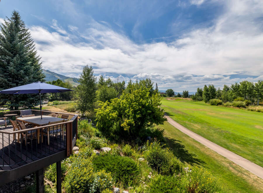 Enjoy breathtaking views from this stunning property! This home features a spacious deck with a dining area, perfect for entertaining or relaxing.