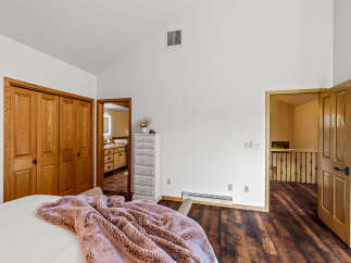 Step into this inviting bedroom, featuring warm wood flooring and ample natural light.