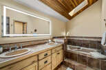 This luxurious bathroom features a stunning wood ceiling with a skylight, creating a bright and airy atmosphere.