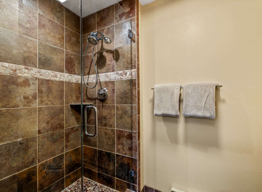 Step into a luxurious bathroom featuring a stunning tiled shower.