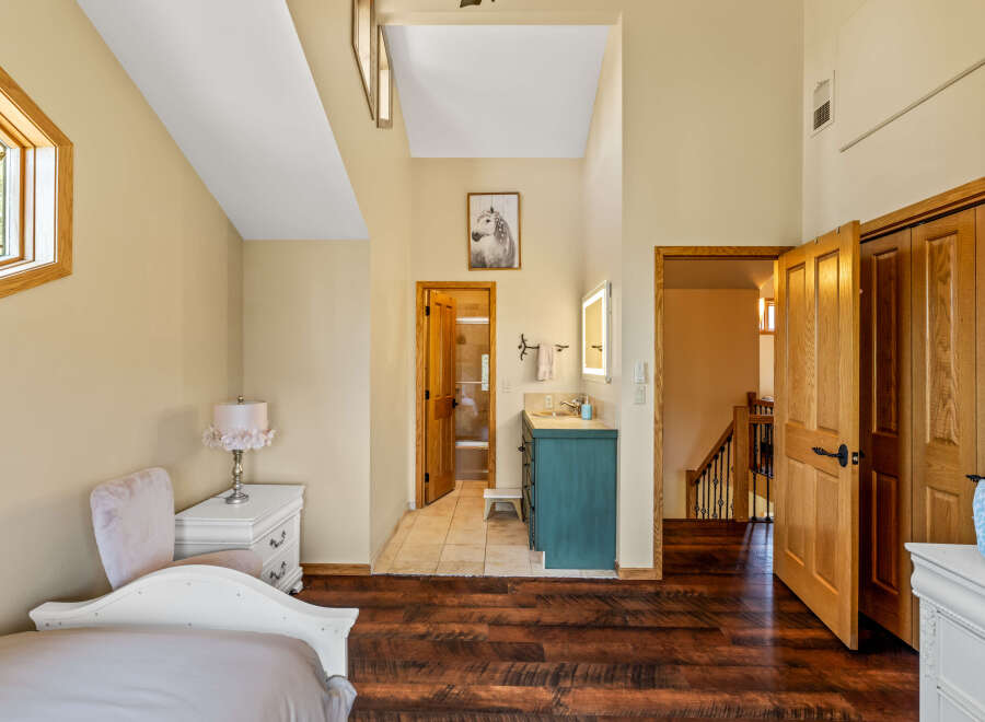 Step into this inviting bedroom, featuring stunning hardwood floors and a unique architectural design.