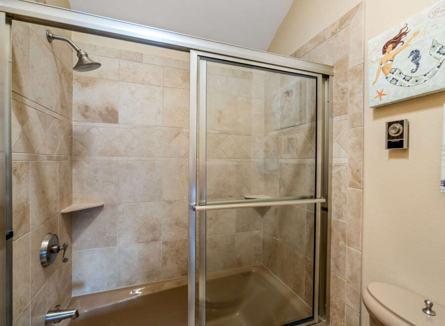 Step into a beautifully designed bathroom featuring a modern shower with a sliding glass door.