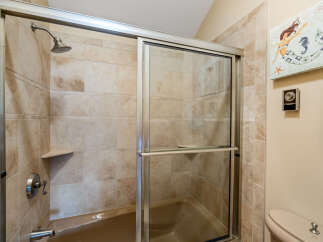 Step into a beautifully designed bathroom featuring a modern shower with a sliding glass door.