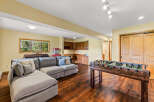 This spacious rec room is perfect for entertaining, featuring a comfortable sectional sofa and a classic foosball table.